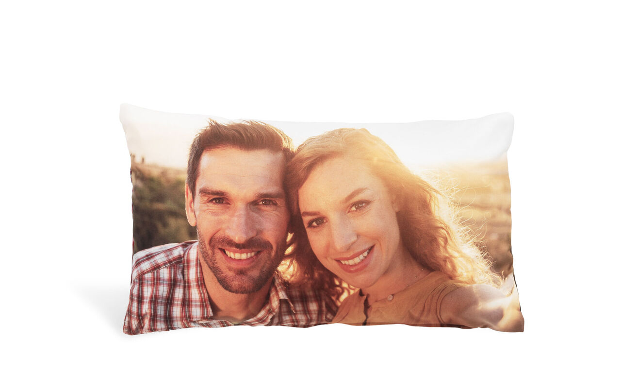 Dos personas sonríen sobre un cojín al sol.
