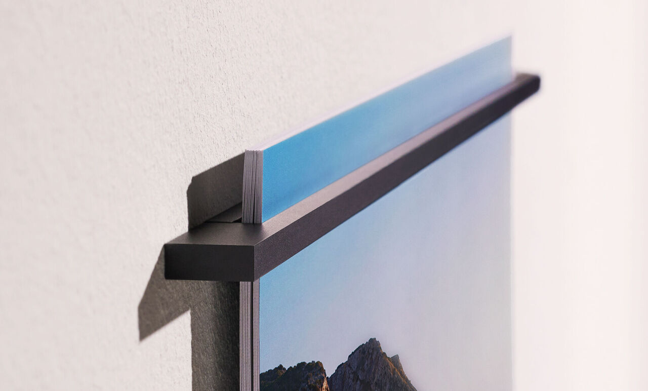 Primer plano de una imagen de pared colgando en una pared que muestra el soporte superior.