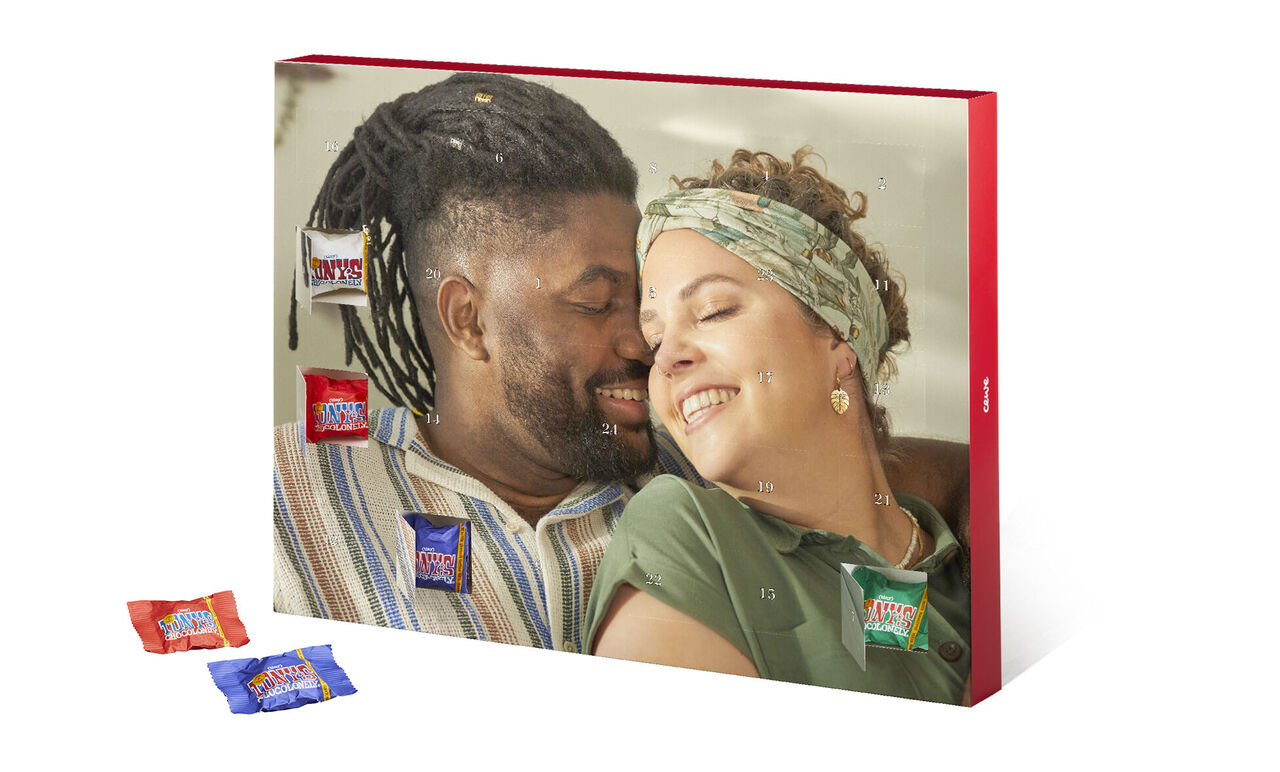 Dos personas se relajan en un banco disfrutando dulces. Varios chocolate en la imagen.