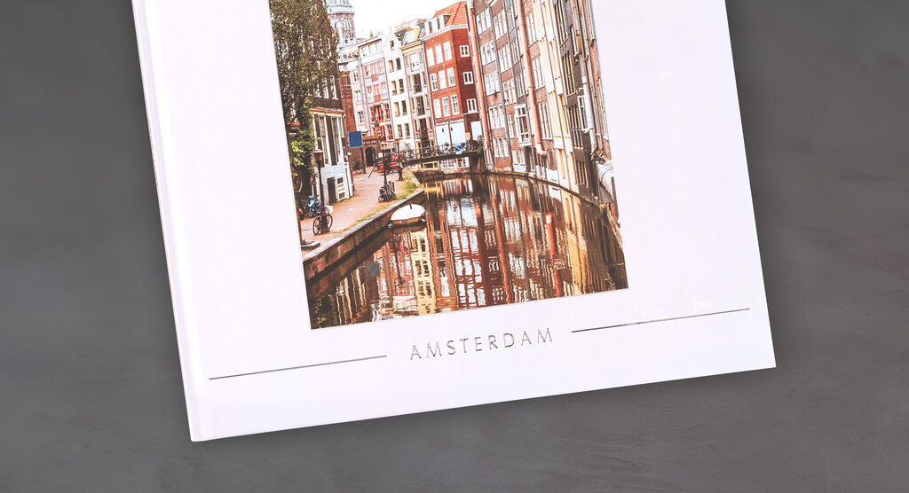 Un CEWE Fotobuch con una foto de Ámsterdam mostrando la arquitectura y el canal.