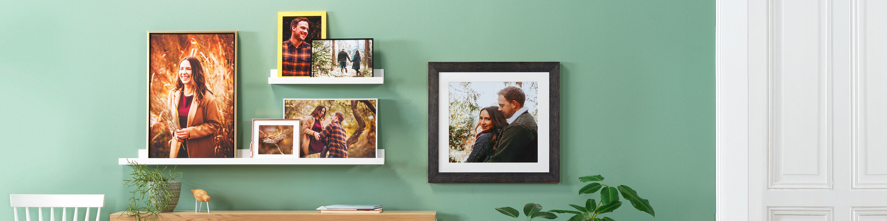 Una pared de imágenes amorosamente diseñada con varias enmarcaciones y fotos de amigos y familia. Los colores son suaves y crean una atmósfera cálida.