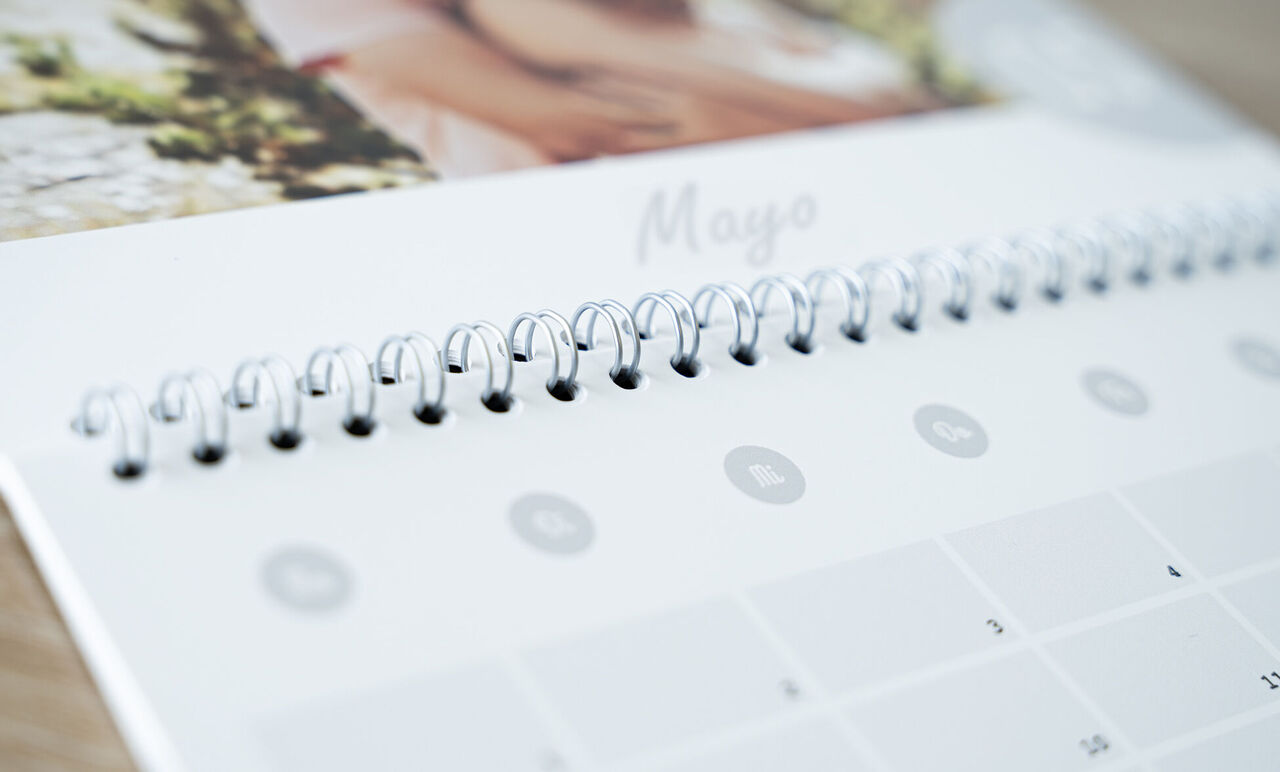 Primer plano de un calendario abierto con fotos y fecha.