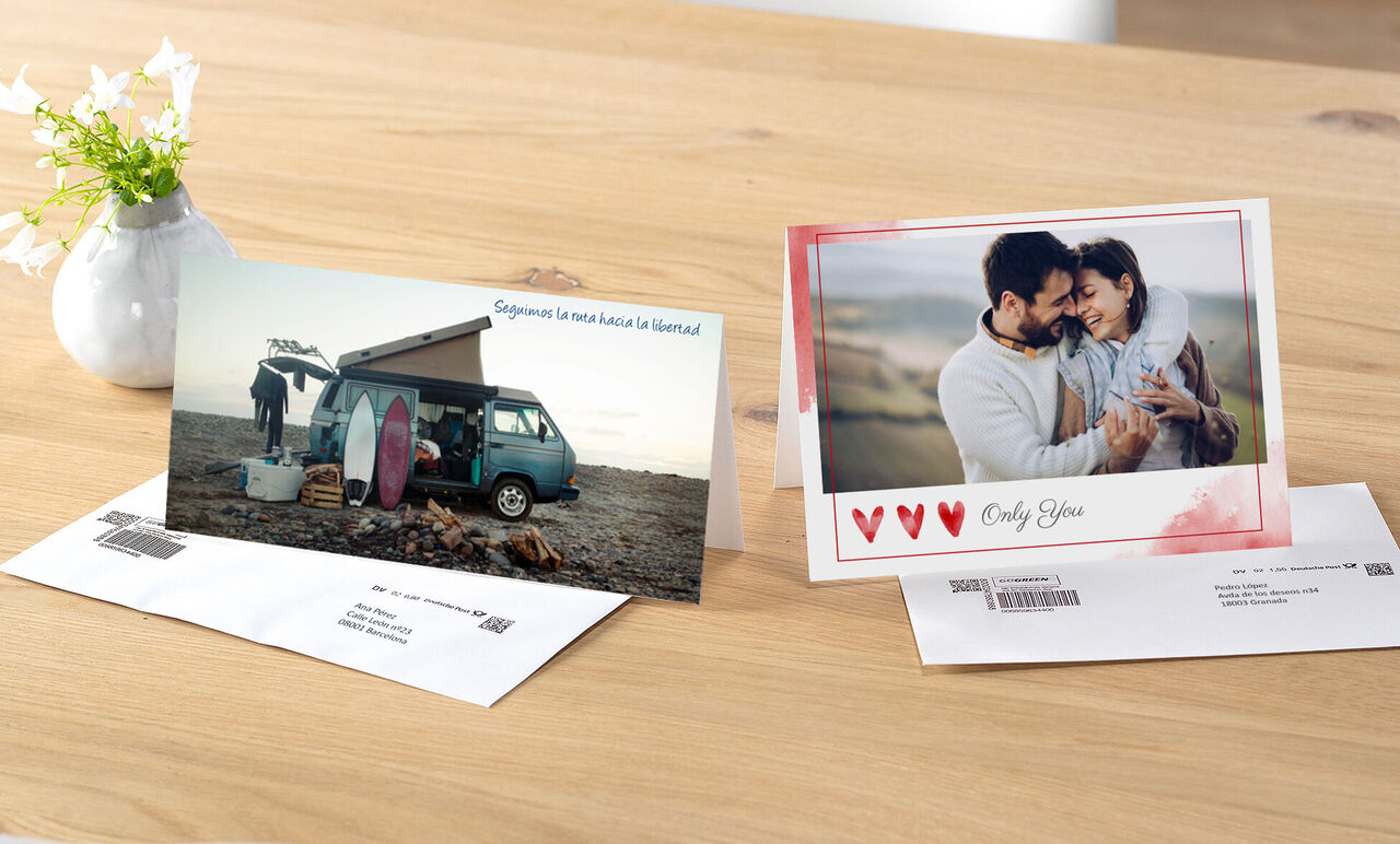 Dos tarjetas de felicitación bellamente diseñadas en una mesa, una con una furgoneta de surf y tablas, otra con corazones rojos.