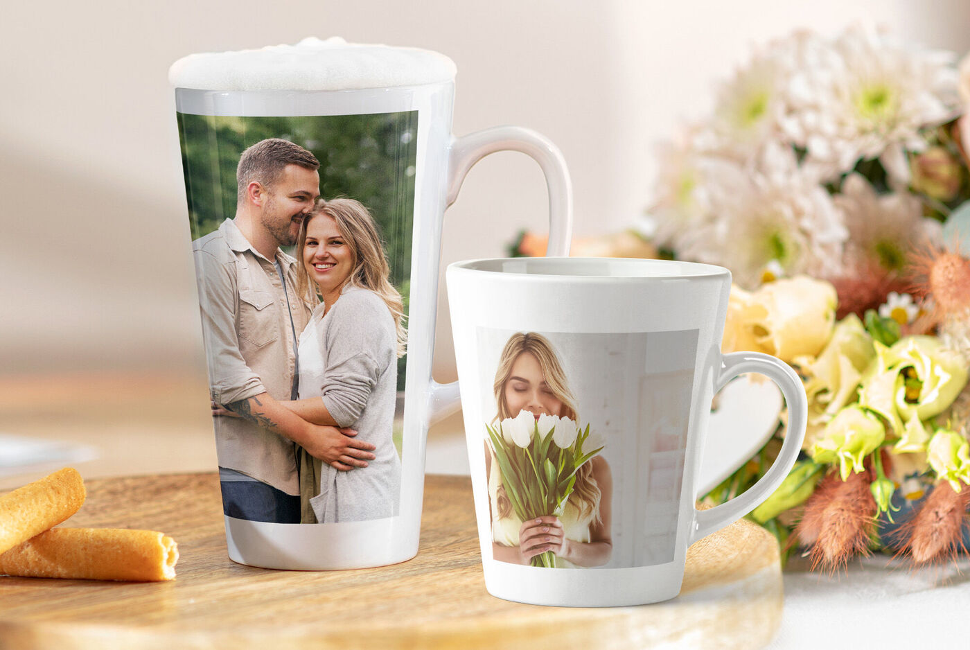 Dos tazas de café personalizadas y de fondo un ramo de flores