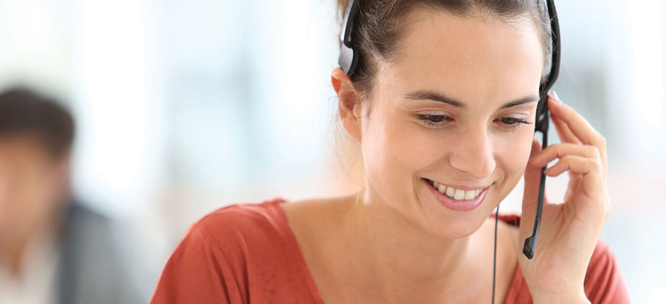 Mujer con auriculares en el teléfono, amable y comprometida.