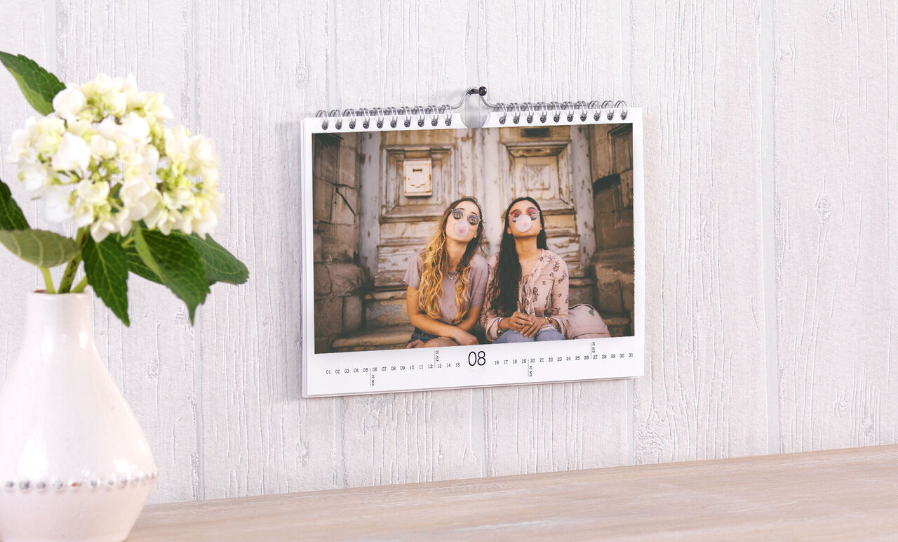 Calendario colgado con dos personas sonriendo y relajándose