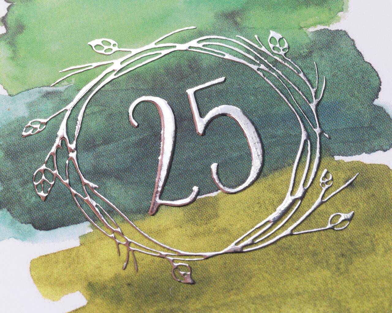 Esfera plateada con el número 25 sobre fondo acuarela verde