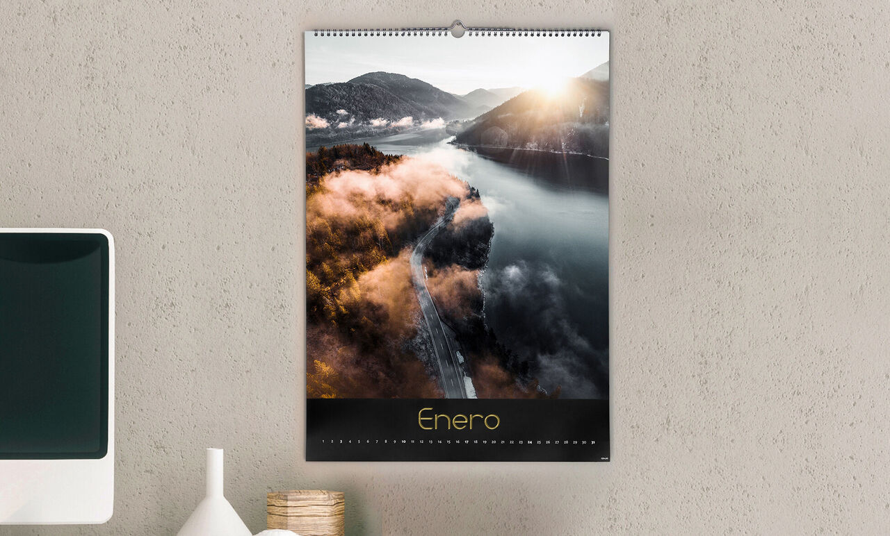 Un hermoso calendario fotográfico con vista de un río, rodeado de colinas al amanecer.