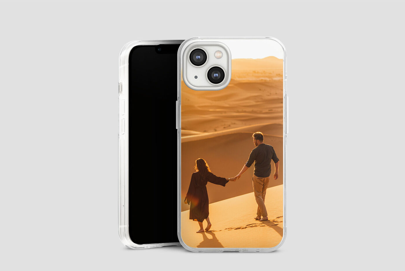 Una pareja camina de la mano por el desierto al atardecer.