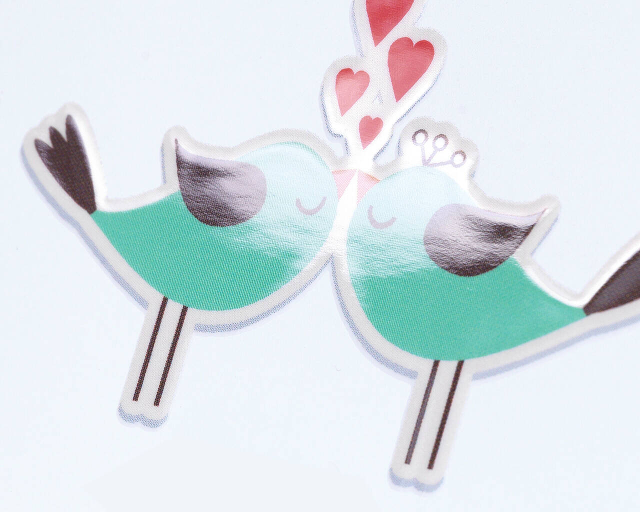 Dos pájaros alegres se besan bajo corazones.