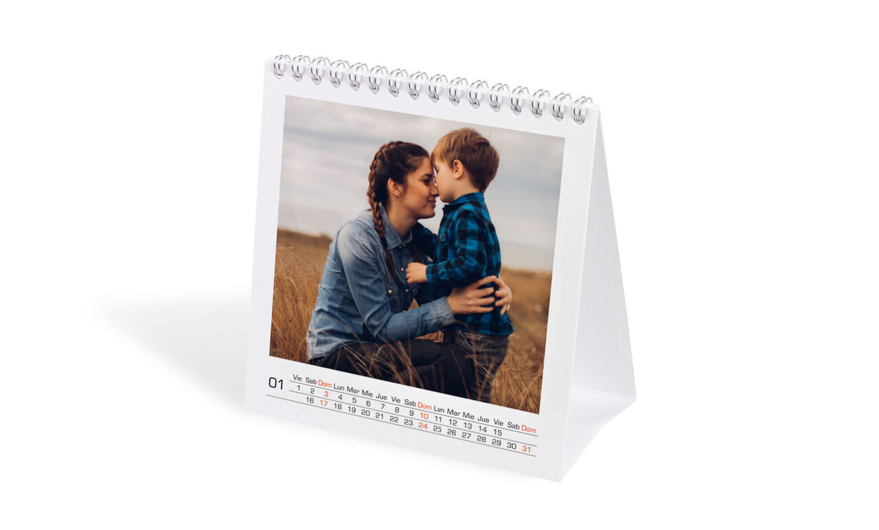 Un calendario de mesa con una dulce imagen de un niño y un adulto en un campo.