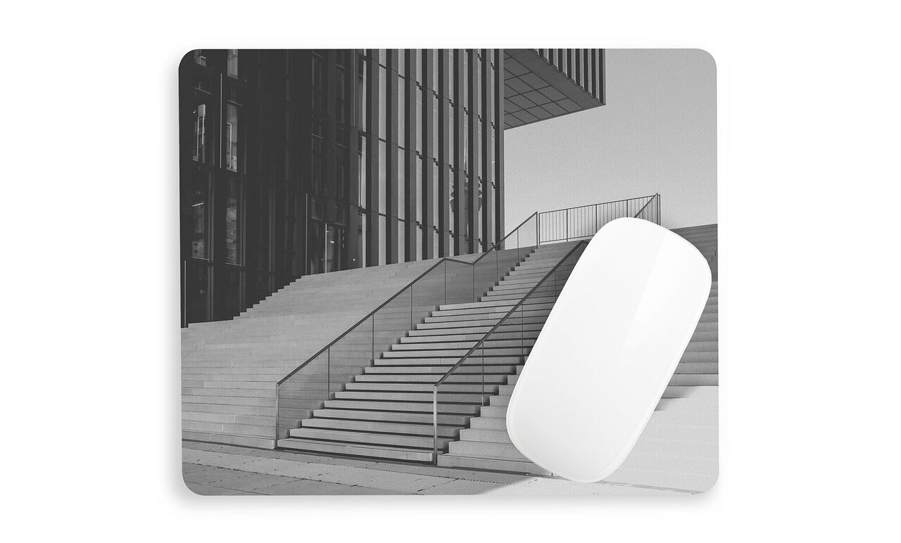 Escalera moderna frente a un edificio en blanco y negro.