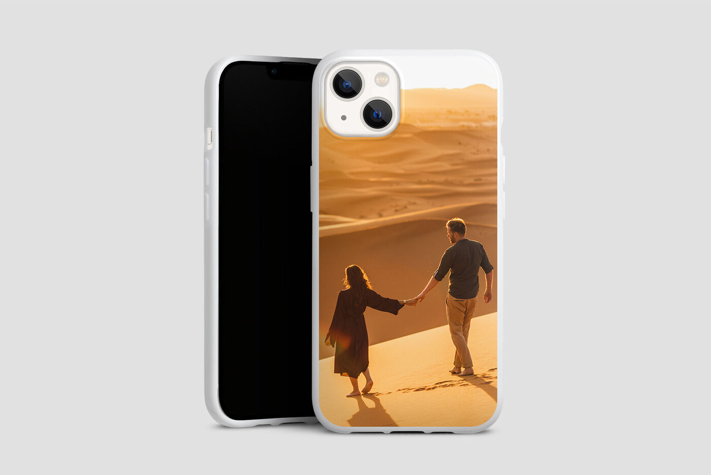 Pareja de la mano caminando por dunas de arena al atardecer