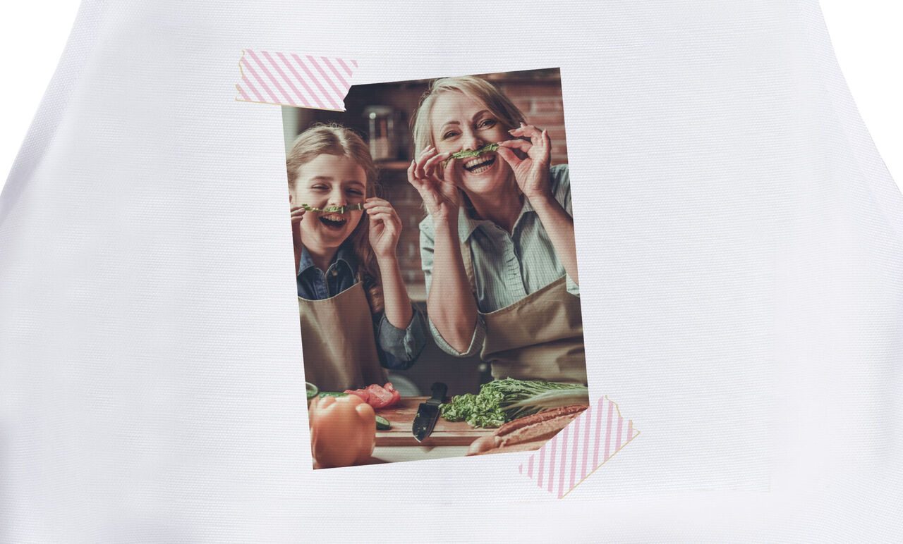 Dos personas con delantales disfrutando de la cocina juntos, rodeados de ingredientes frescos.