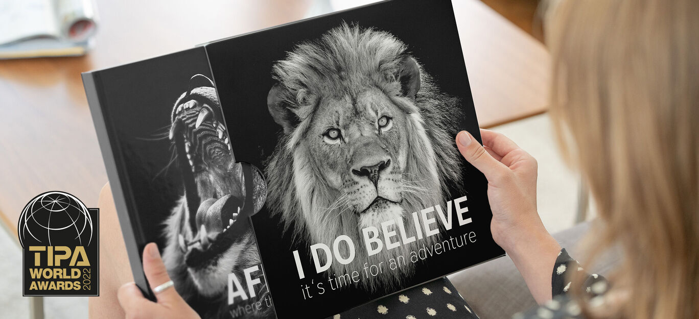 Persona con un fotobuch en la mano, con un león en la portada.