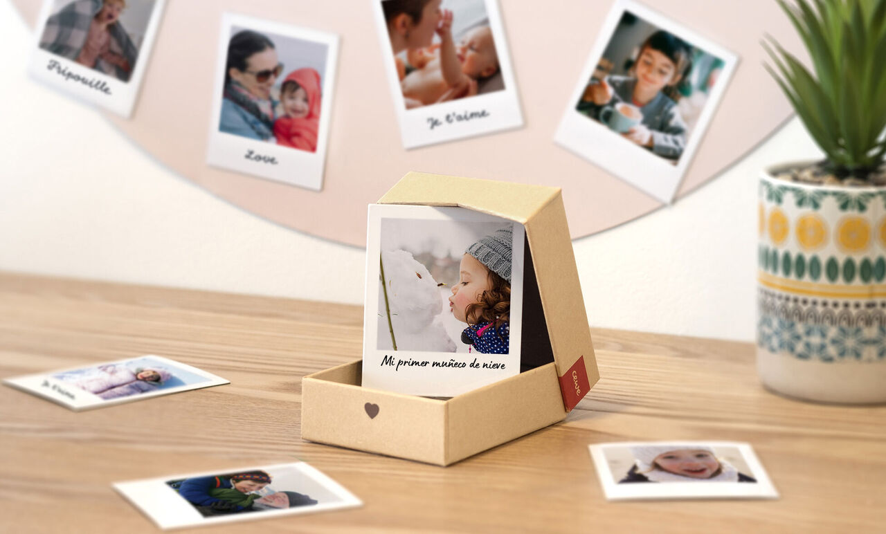 Un regalo diseñado con amor con una foto personalizada dentro de la caja, rodeada de fotos en una mesa