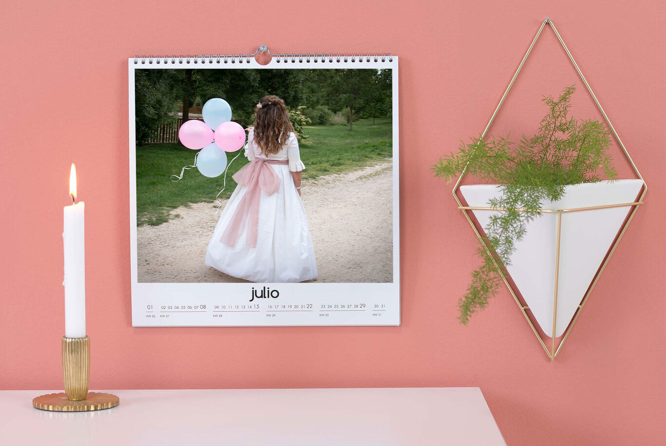 Una niña con globos mira un calendario que lleva su nombre.