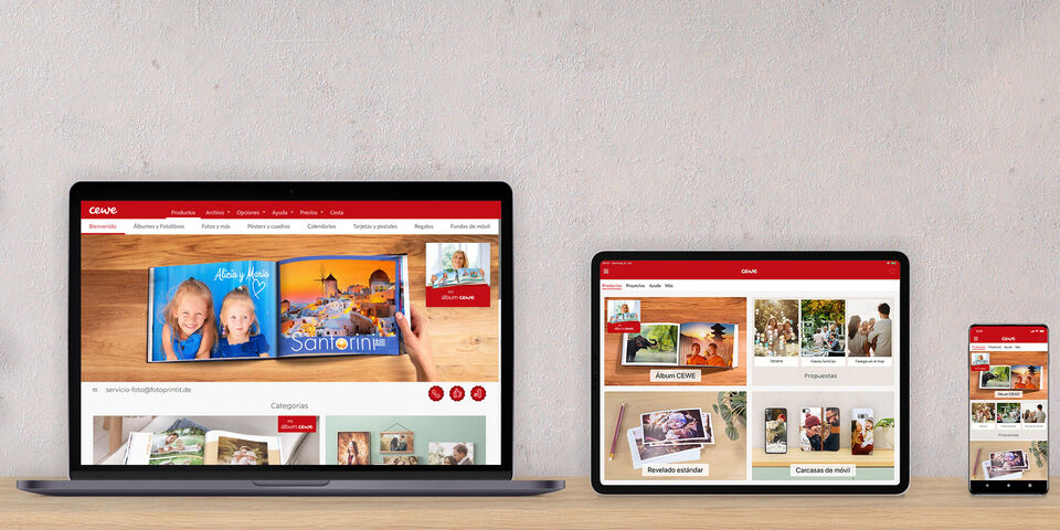 Tres dispositivos muestran la web de CEWE Fotobuch con álbumes y fotos.