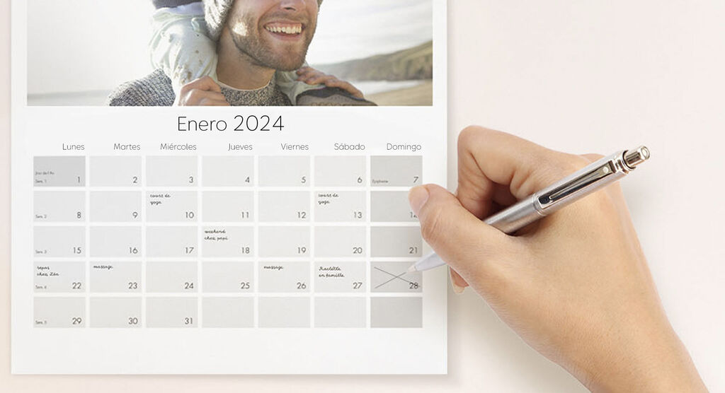 Una mano marca un día en un calendario para enero 2024