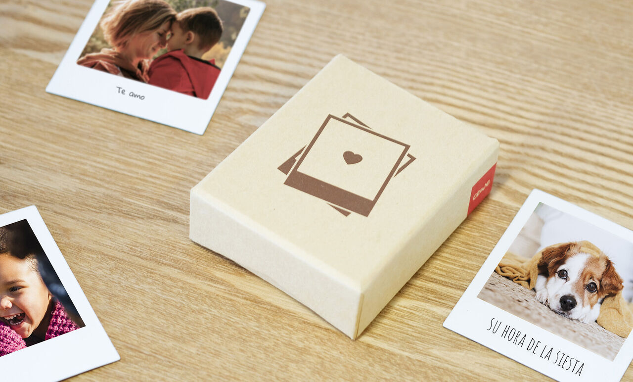 Una caja de regalo bellamente diseñada con fotos, rodeada de otros recuerdos.