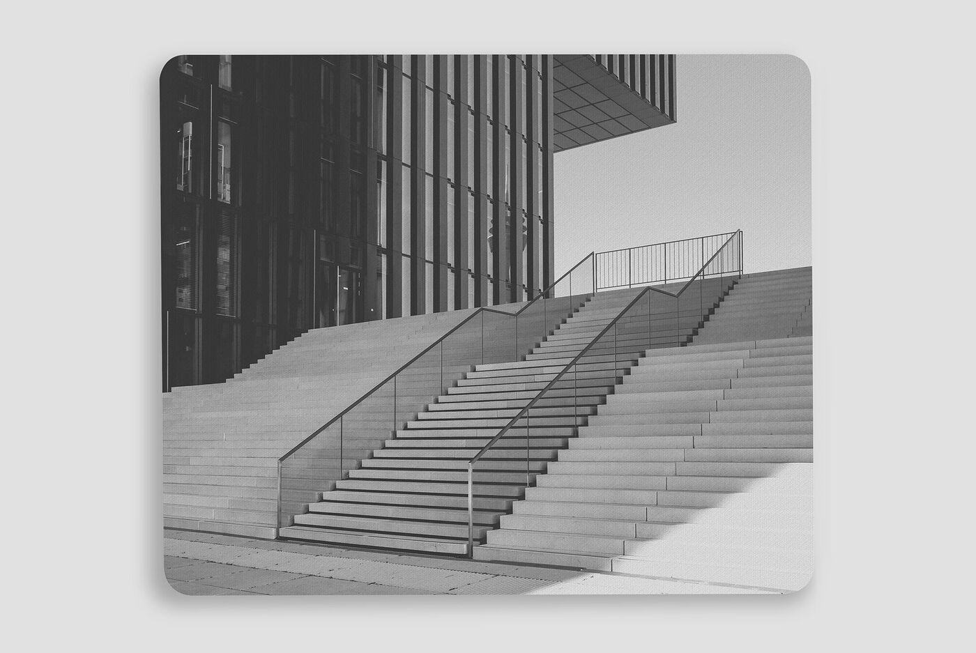Escalera moderna frente a un edificio de cristal.