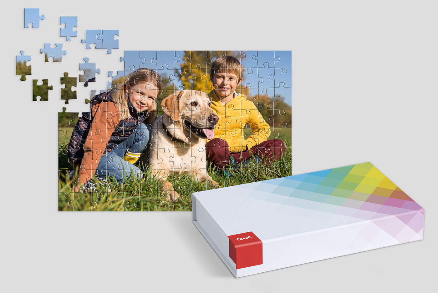 Un perro con dos niños está sentado en el césped, rodeado de piezas de puzzle.