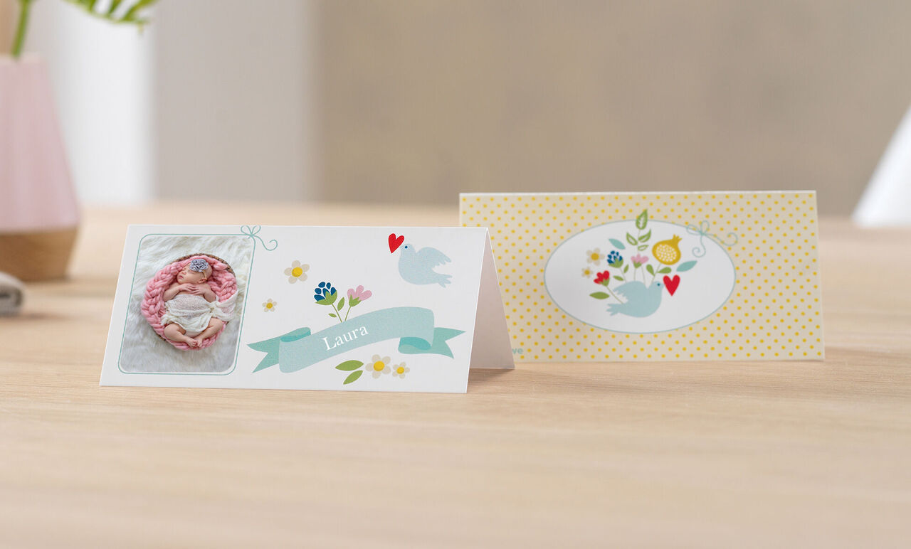 Dos tarjetas de felicitación bellamente diseñadas con motivos coloridos sobre una mesa.