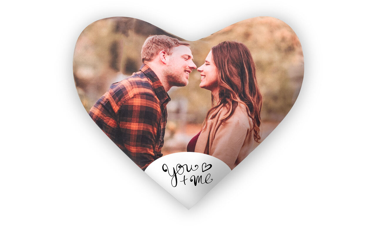 Una pareja se besa en un gráfico con forma de corazón, rodeada de colores cálidos y elementos naturales