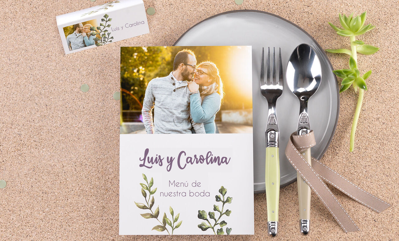 Menú de boda con motivo floral y cubiertos.