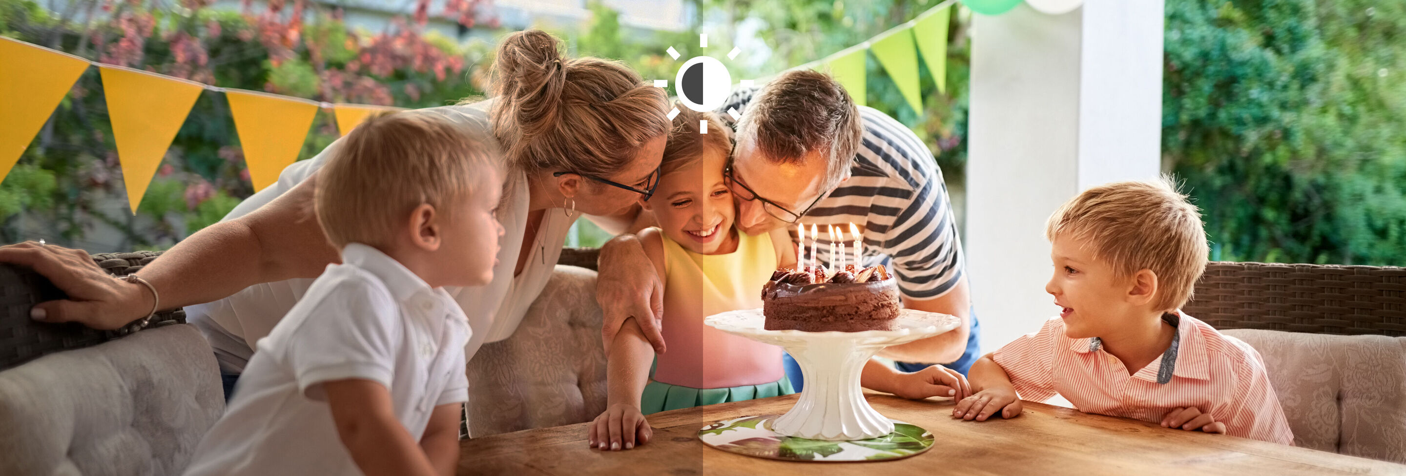 Familia celebra un cumpleaños con pastel y velas en el jardín