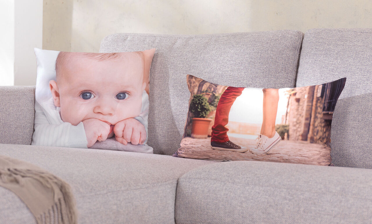 Una sala acogedora con dos cojines decorativos en un sofá gris, uno muestra una pareja besándose