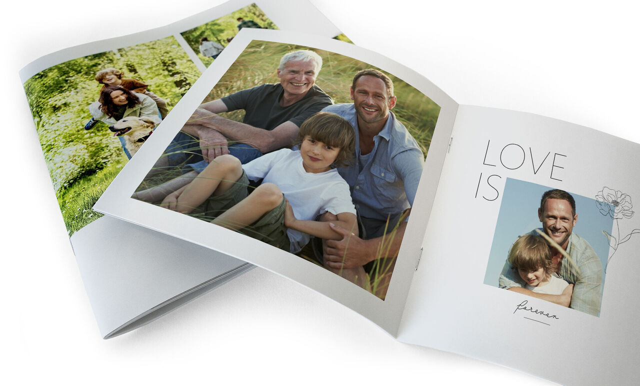 Libro de fotos abierto con imágenes de momentos felices, rodeado de naturaleza.
