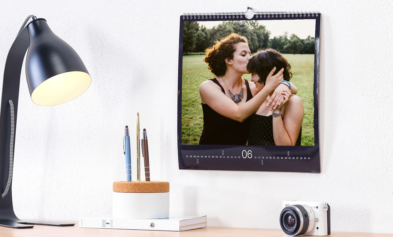 Dos personas se abrazan frente a un calendario.