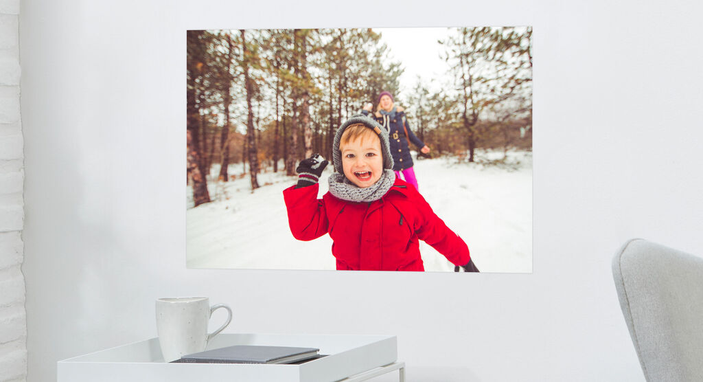 Dos niños juegan alegremente en la nieve, el sol brilla, árboles al fondo.