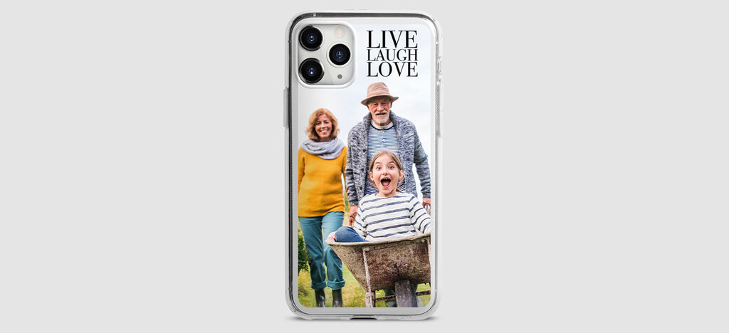 Una familia feliz posa al aire libre. Los padres y el niño transmiten alegría. Un lema inspirador en la esquina: "VIVIR RÍE AMOR".