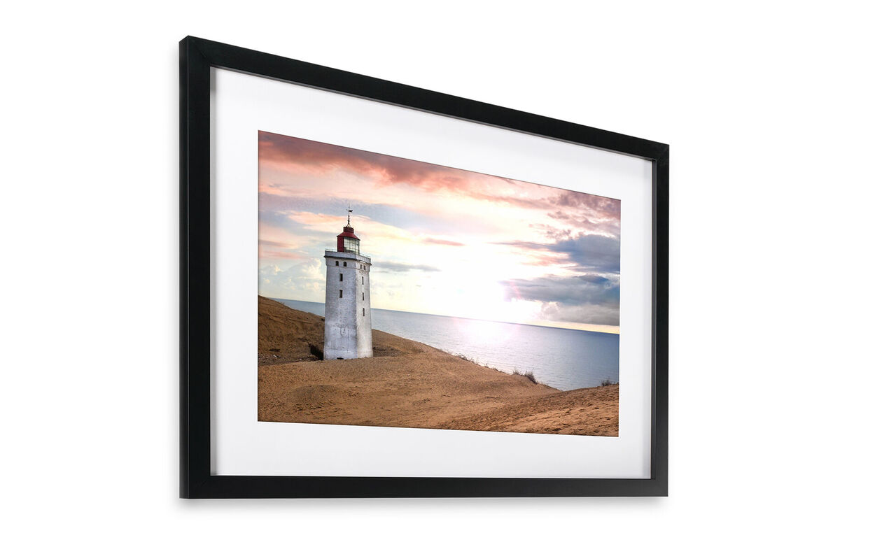 Un hermoso faro en la costa, rodeado de suaves colinas y una puesta de sol pintoresca.