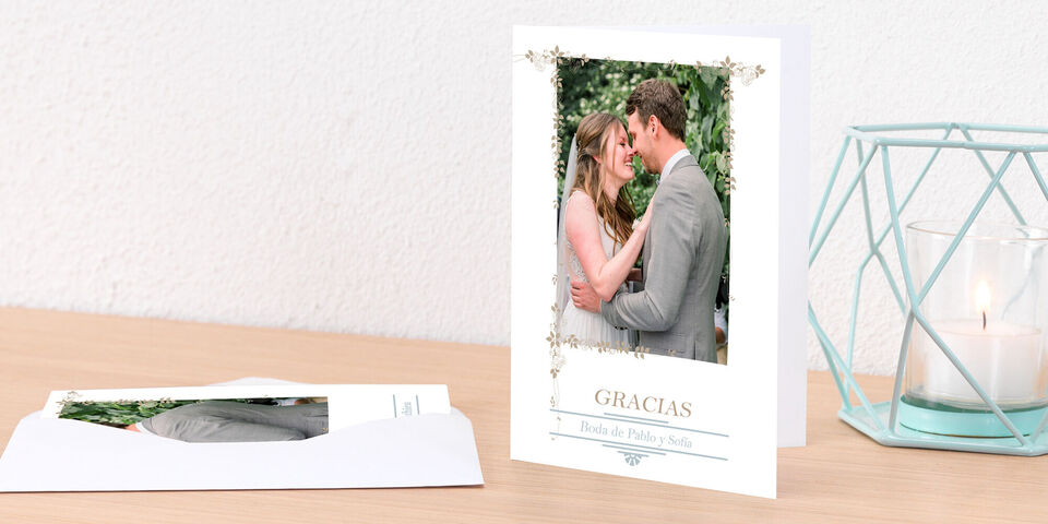La imagen muestra a una pareja de novios abrazándose felizmente. La escena tiene una tarjeta CEWE decorativa que dice 'GRACIAS'.