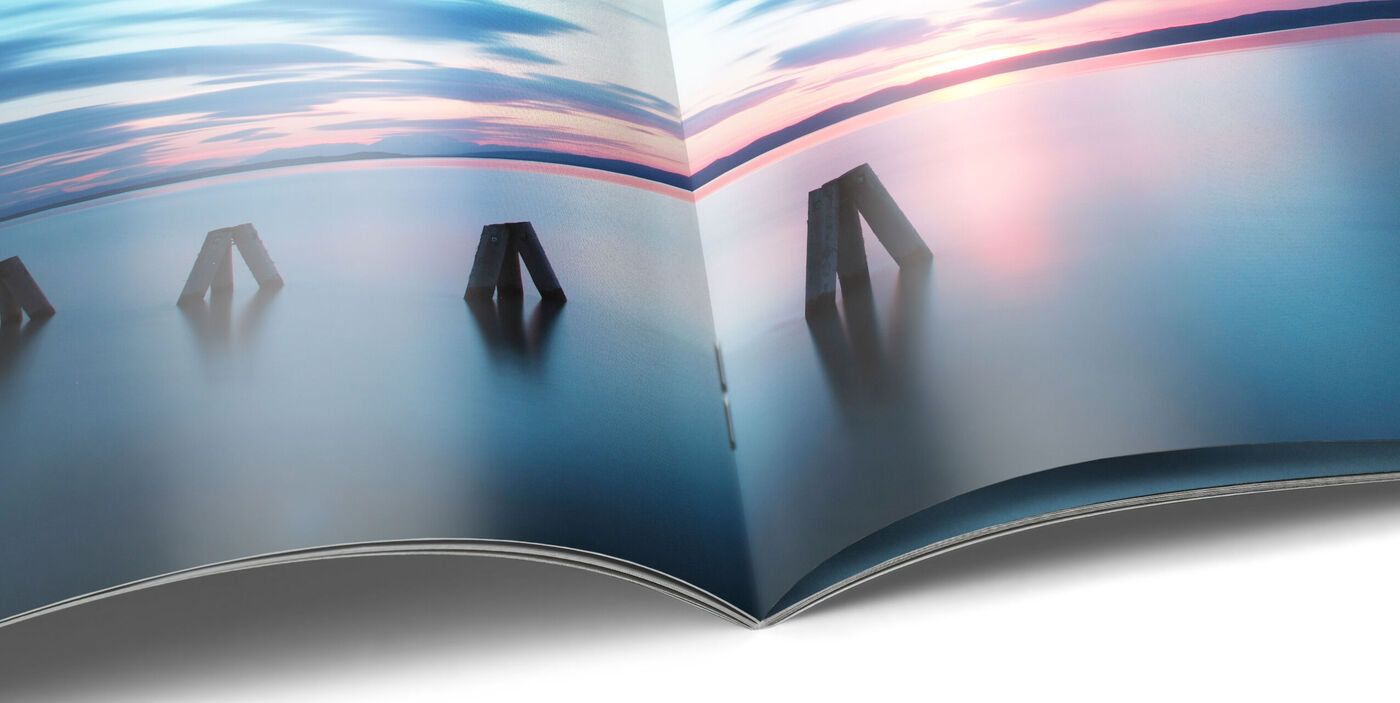 CEWE FOTOBUCH abierto con paisaje terrestre y marítimo fotografiado en una página