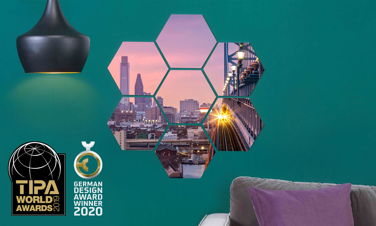 Decoración mural colorida con fotos hexagonales de una vista de ciudad al atardecer y un puente