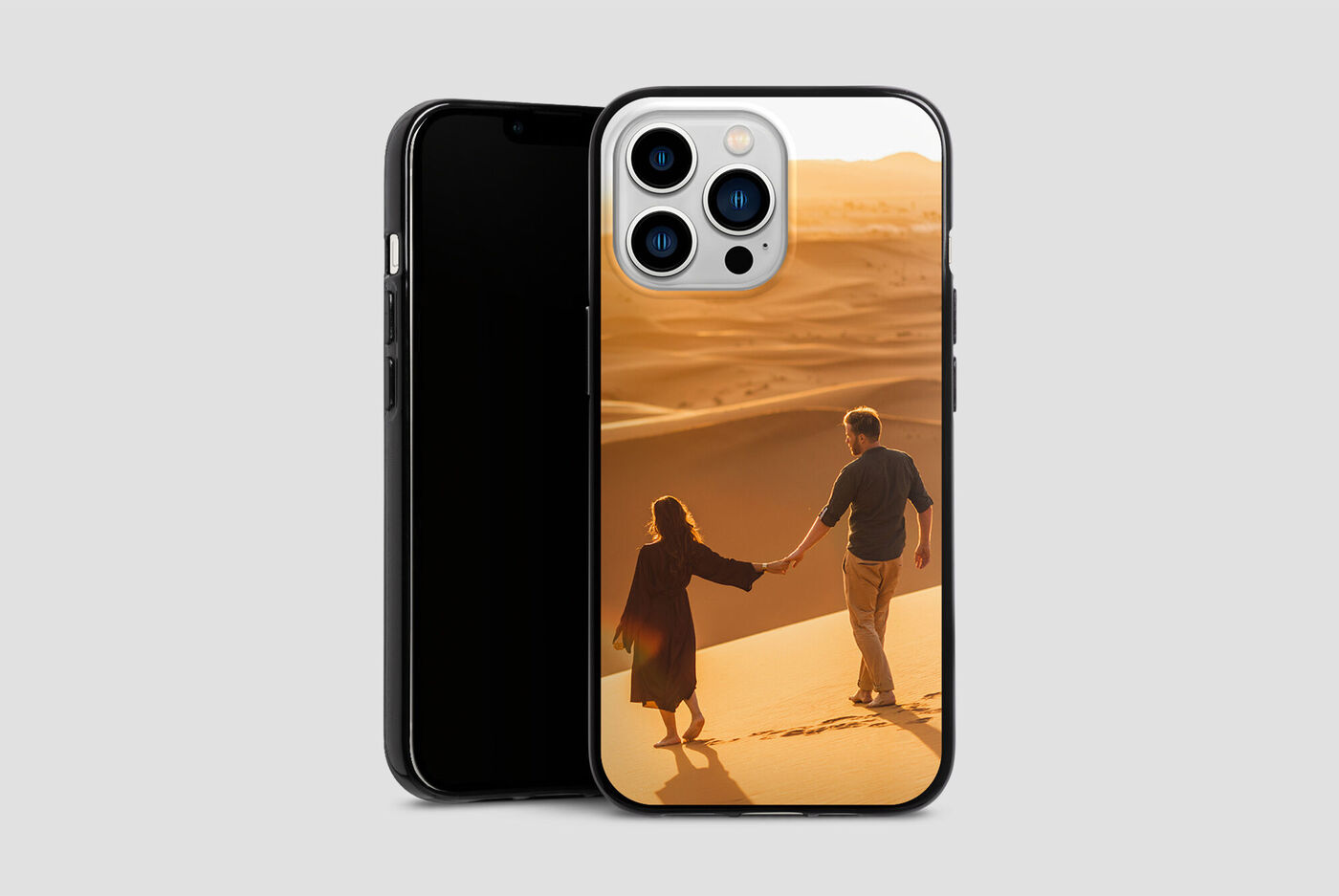 Una pareja toma de la mano y camina por las dunas de arena. El paisaje naranja irradia calor y felicidad.