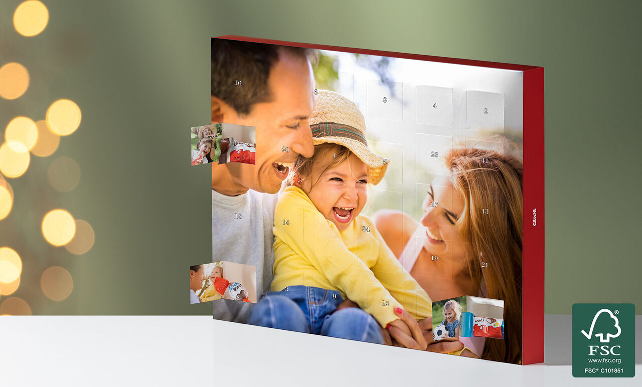 Un calendario fotográfico CEWE con fotos coloridas y días del calendario al frente. Una familia feliz mira las fotos.