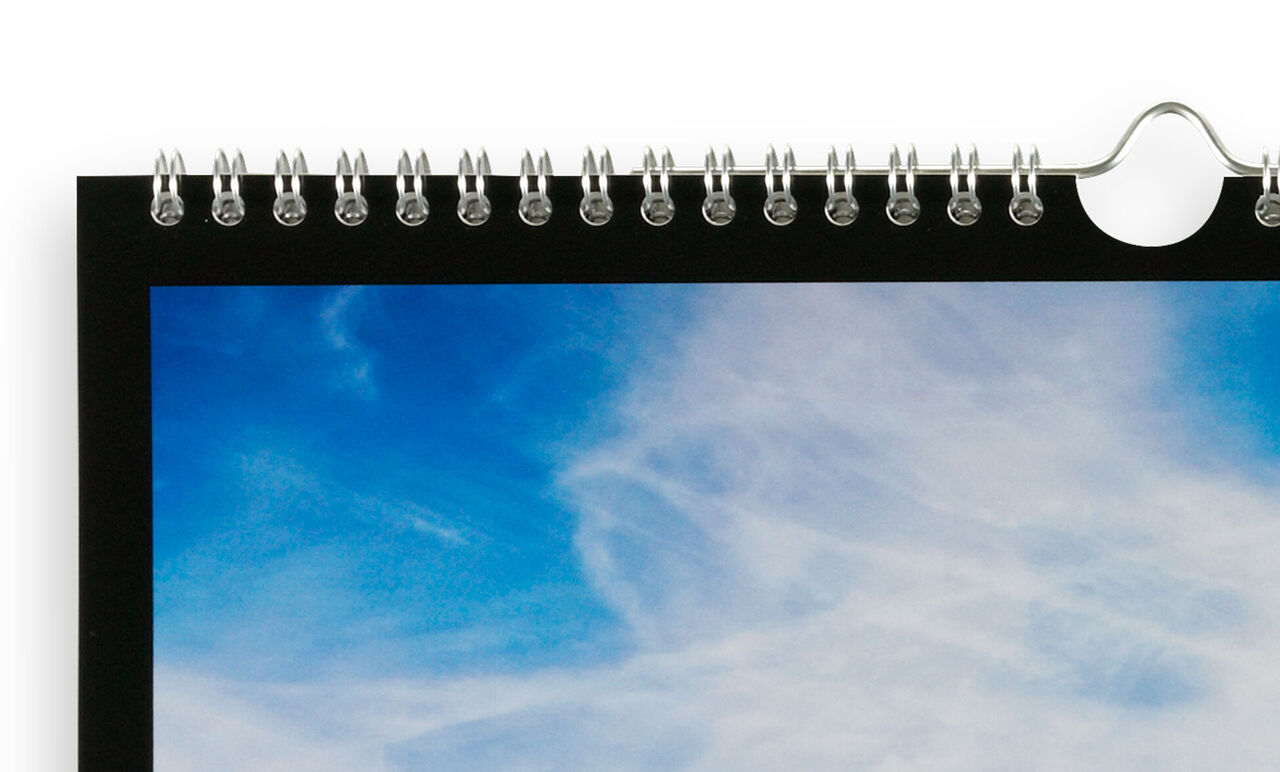 Parte de un calendario de pared con un cielo colorido y nubes