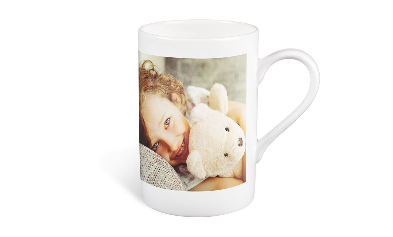 Una taza con una foto y un peluche.