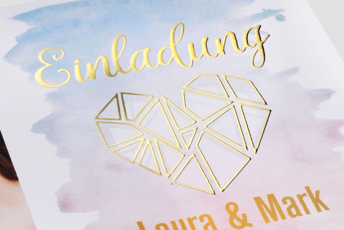 Invitación con diseño de corazón dorado sobre fondo pastel