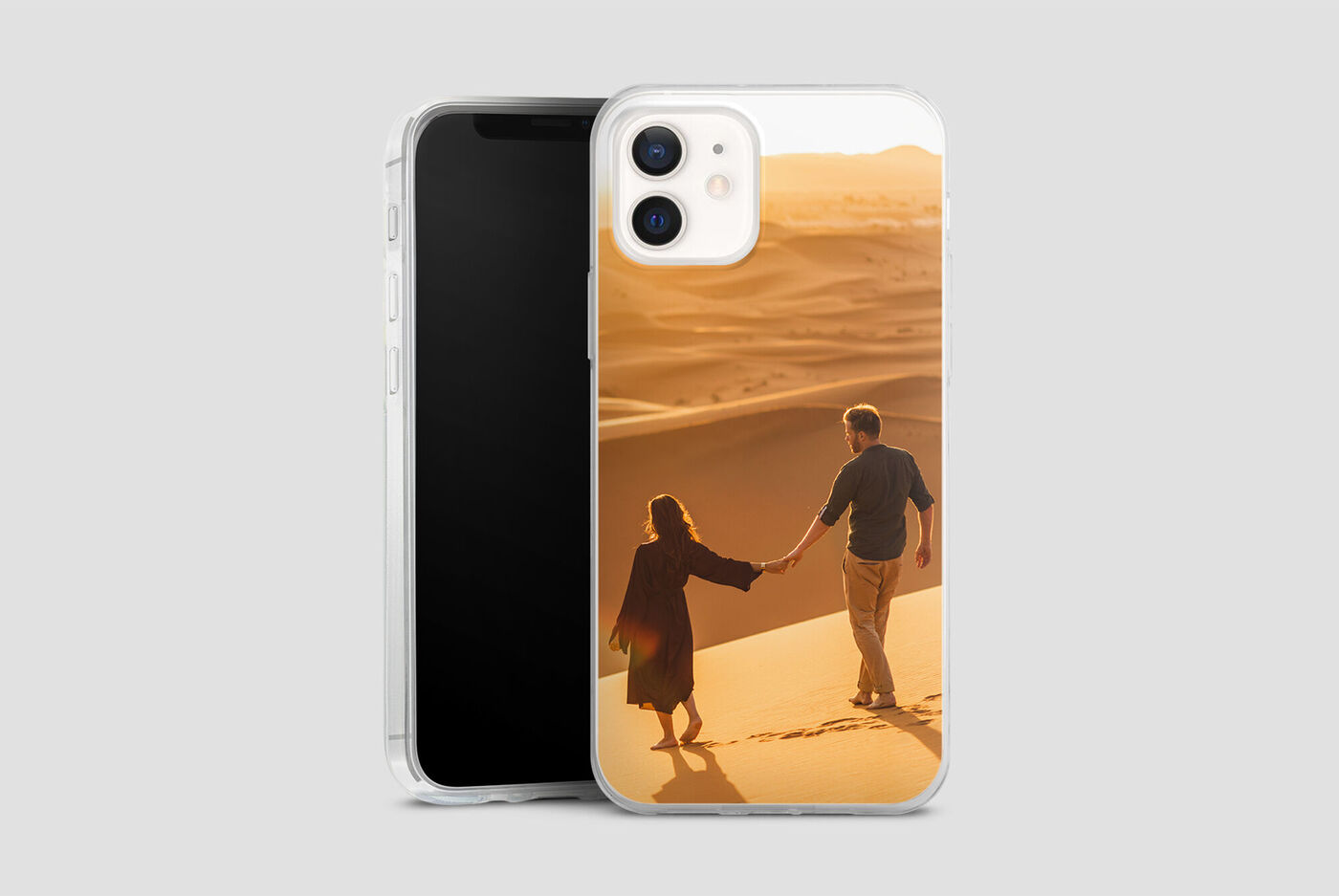 Pareja de la mano en la arena durante el atardecer.