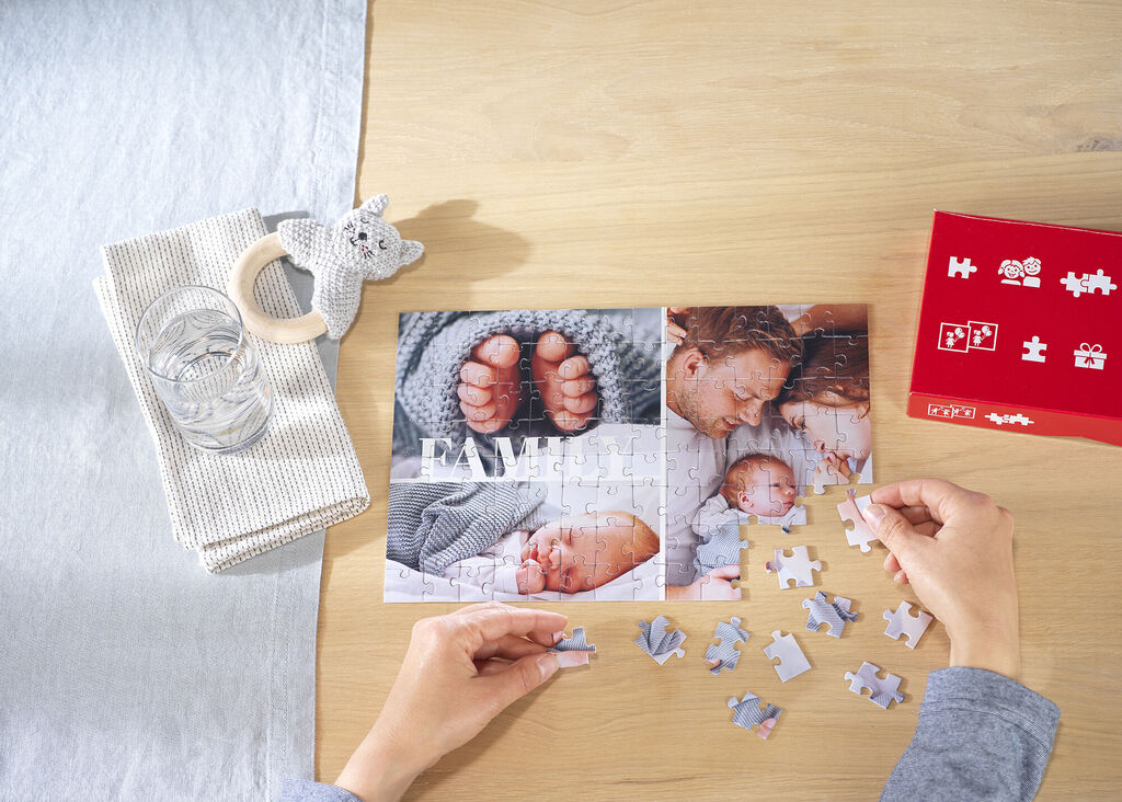 Persona construyendo un puzzle personalizado con fotos familiares un padre y un bebé.