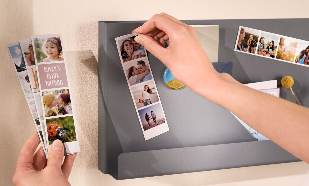 Alguien saca una tarjeta de foto de un estante gris con más recuerdos fotográficos.