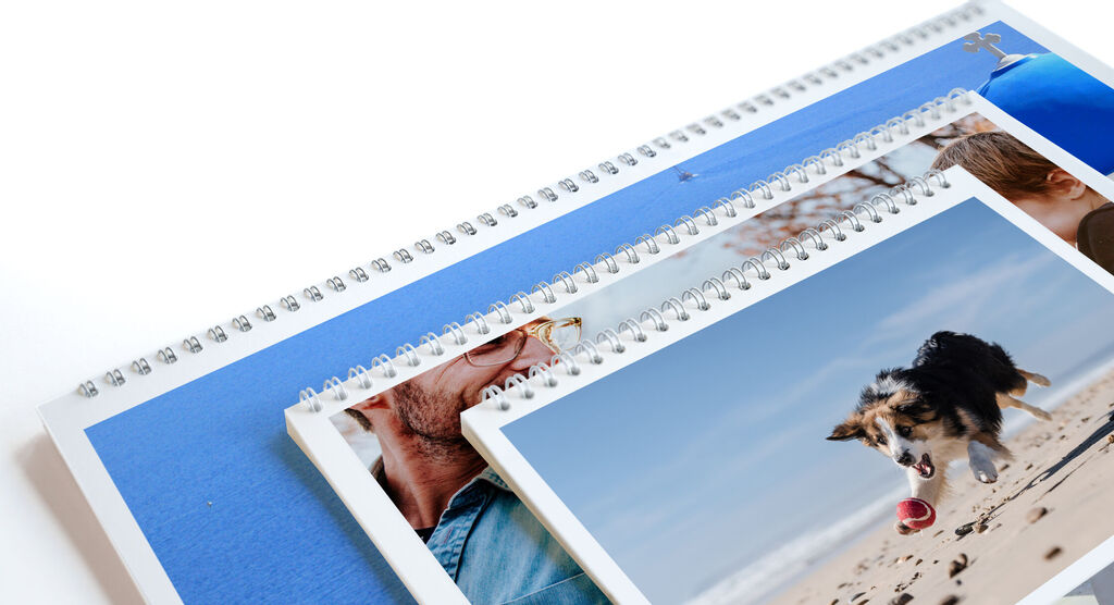 Tres calendarios CEWE con diferentes fotos en una mesa.