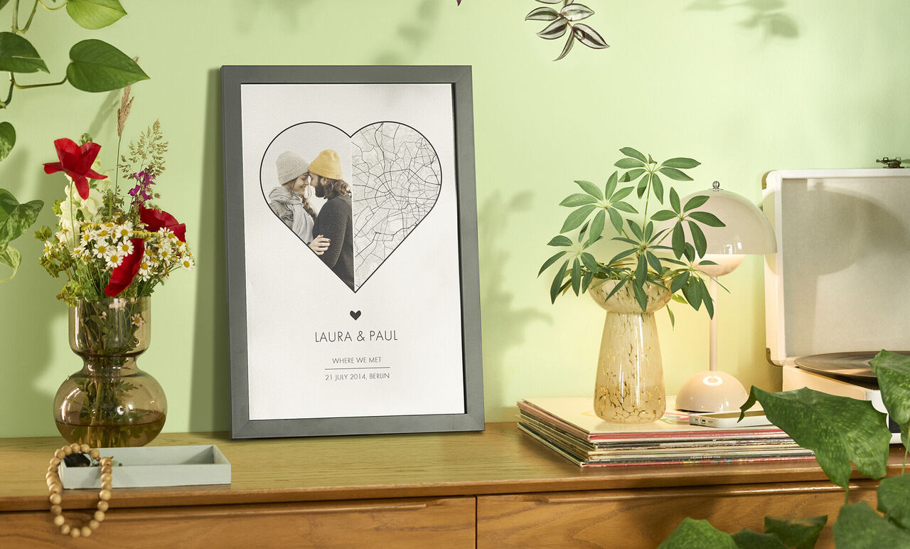 Una hermosa imagen en forma de corazón con los nombres Laura y Paul. Plantas y decoración al fondo.