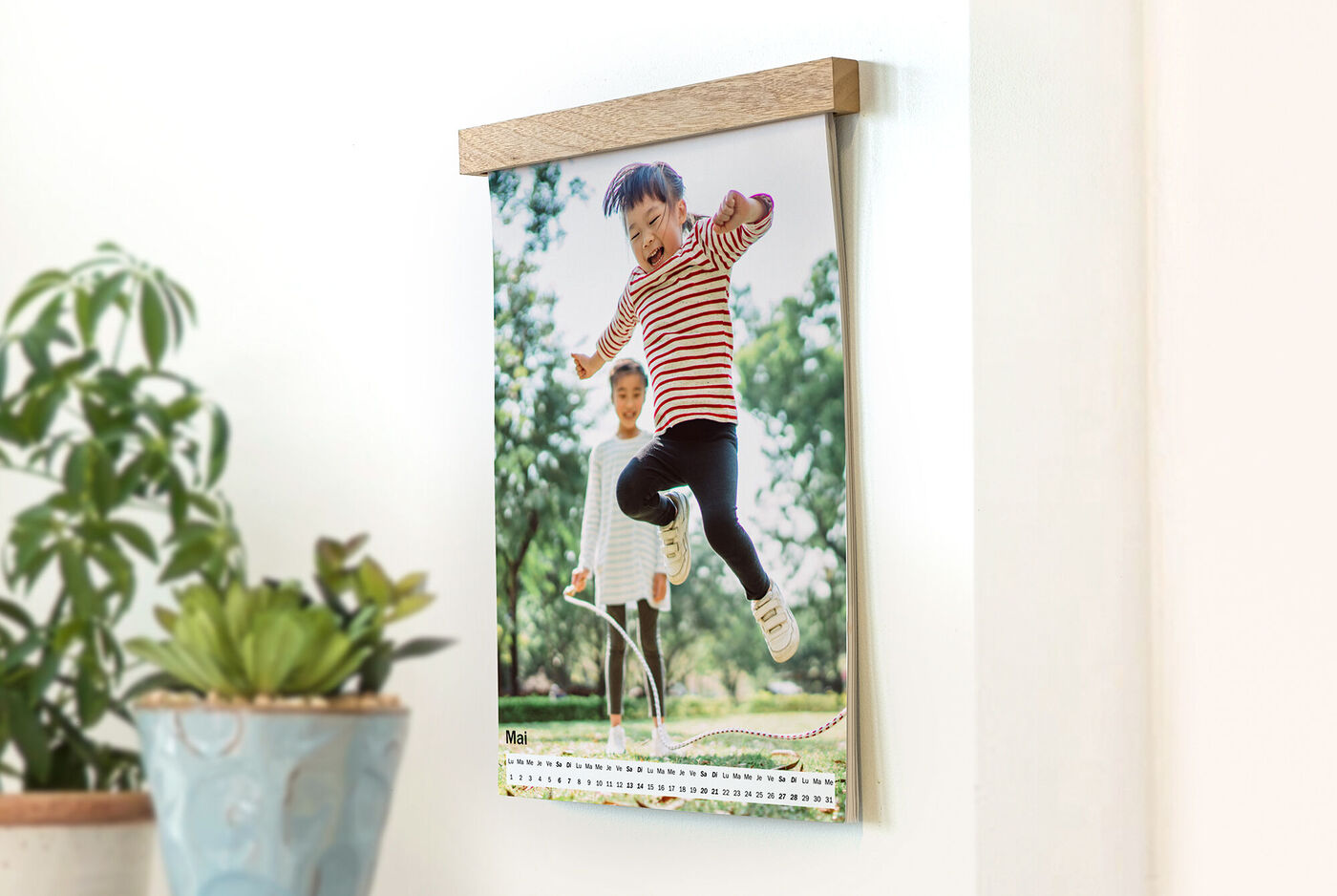 Un niño feliz salta de un banco, mientras otro niño sonríe en el fondo, en un calendario.
